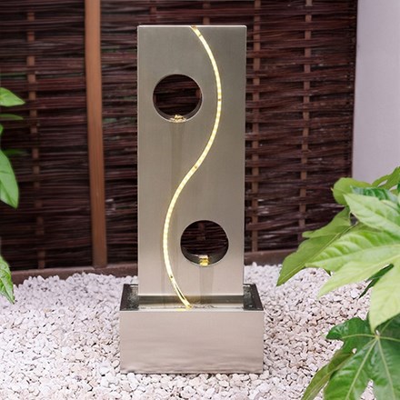 Stainless steel water wall with cut-out circles and swirl with LED light